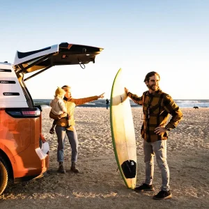 Rodzina, która przyjchała busem na plażę i wybiera się na surfing