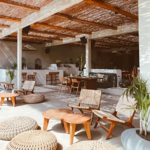 Słoneczny bar bądź restauracja z drewnianymi meblami oraz wiklinowym dachem