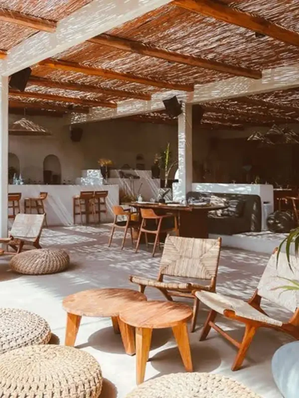 Słoneczny bar bądź restauracja z drewnianymi meblami oraz wiklinowym dachem